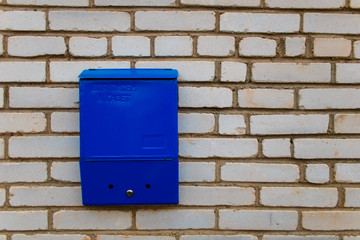 Blue mailbox for letters and newspapers on a brick wall in Belarus