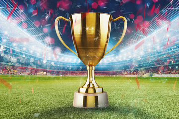 Golden winner s cup in the middle of a soccer stadium with audience