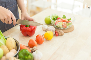 Young Woman Cooking Healthy Food   and Vegetable Salad in the kitchen at home.  Healthy Lifestyle.