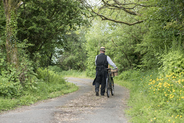 Rear view of a 1940 delivery man on a country road rural setting 