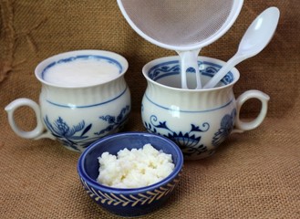 Milk kefir grain and fresh homemade kefir fermented milk with plastic sieve and spoon