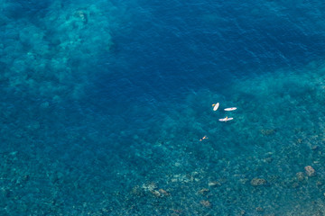 Fototapeta na wymiar Aerial view of people paddling on tropical water.