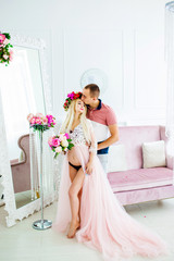 Sweet couple standing near the mirror in a pink white studio