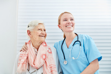 Lächelnde Pflegedienst Frau mit glücklicher Seniorin