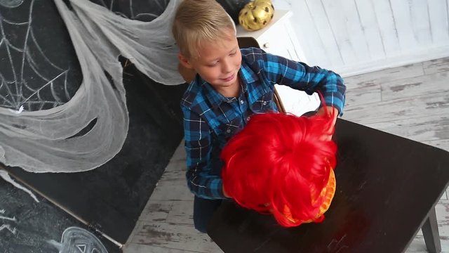 Young boy playing with holiday pumpkin. Halloween celebration.