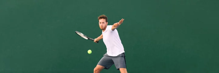 Fototapeten Tennis player man hitting ball with forehand hit on outdoor court playing game. Male sports athlete working out cardio traning. Panorama banner on green background. © Maridav