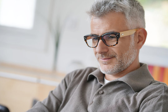 Smiling middle-aged man connected with tablet