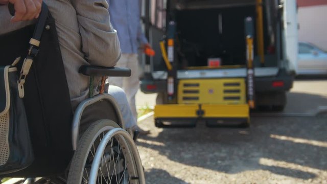 Lifting equipment for people with disabilities - man in wheelchair near the vehicle