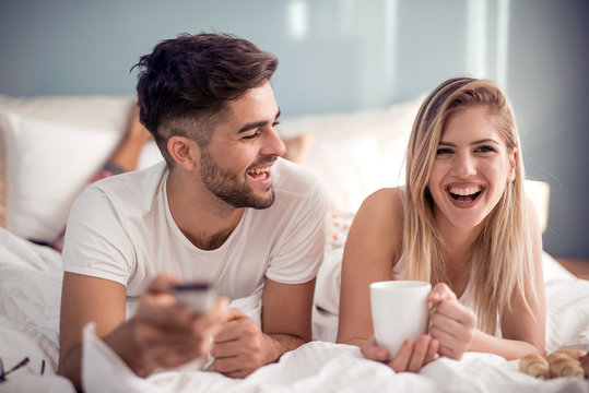 Couple In Bed Watching TV