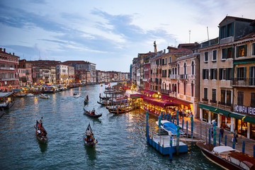 Obraz premium Canal Grande with boats and lights in Venice at Sunset. Next to famous Rialto Bridge and the Street 