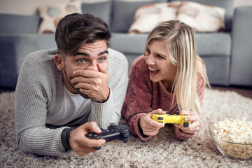 Happy couple play video game at home