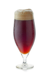 Glass of dark beer with foam on white