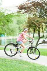Fototapeta na wymiar Girl riding her bicycle on park trails 