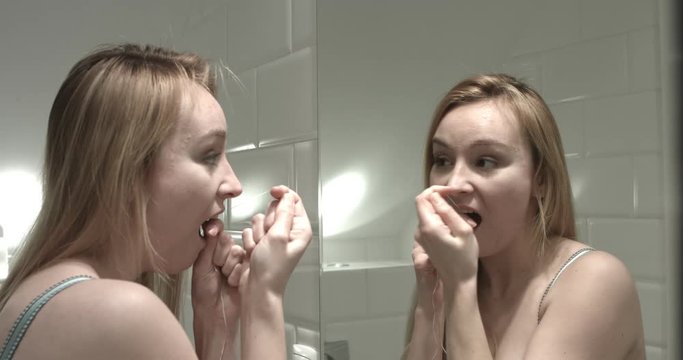 Cute girl using dental floss