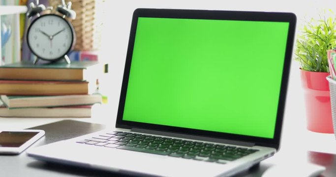 Black desk with a laptop, cell phone and digital tablet. Chroma key. Perfect to put your own images or videos. Dolly in.