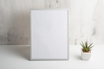 Empty white frame with flower on wall background. The concept of design and font inscriptions and...