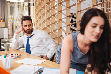I like her. Excited handsome man sitting at the table and checking out his hot worker