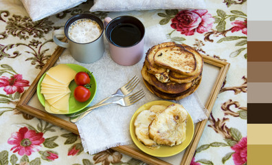 Delicious breakfast in bed with toast and a big cup of coffee with color palette