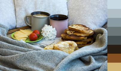 Delicious breakfast in bed with toast and a big cup of coffee with color palette