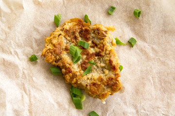 Fresh fried pork chops sprinkled with green onions and ketchup.  Arrangement  on the wrapping paper