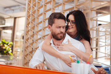 Hugging. Alert dark-haired woman seducing her boss and touching him