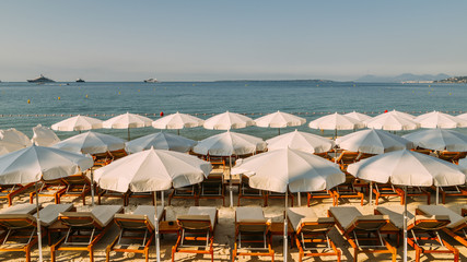 Rows of empty beach lounges and sun umbrellas on a beach in Juan les Pins, France