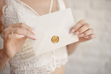 close-up woman with slim body holding invitation envelope card in hands, rear veaw.