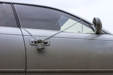 Fototapeta na wymiar old lock on the chain on the driver's car door