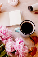 Beauty flat lay with a diary, cup of coffee, accessories and peonies on a marble background