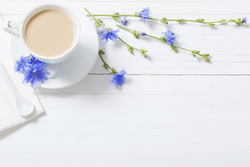 Drink from chicory in a cup on the white wooden table
