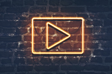 Neon music play sign on dark brick wall background