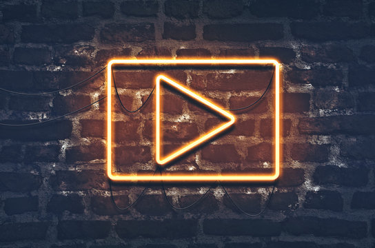 Neon music play sign on dark brick wall background - Powered by Adobe