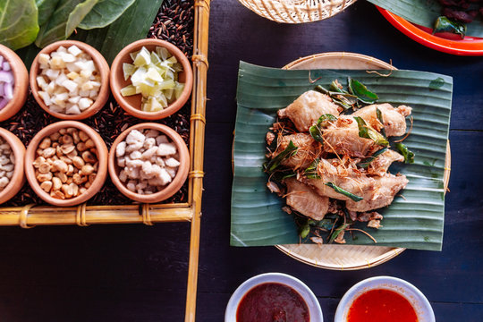 Fried chicken wings in Thai northeastern style with garlic and kaffir lime leaves served on banana leaf.