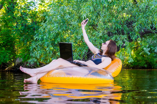Business woman sitting in an inflatable ring in a river space.