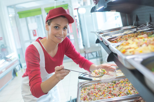 buffet female worker servicing food in cafeteria