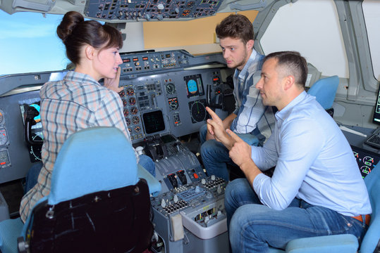 Young people in cockpit of aircraft with instructor