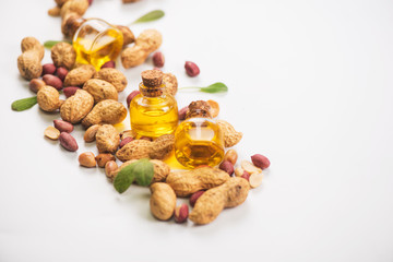 Natural peanuts with oil in a glass jar on a white background