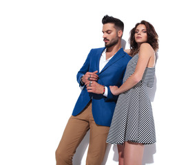 Naklejka premium sexy woman holds his casual man by his forearm