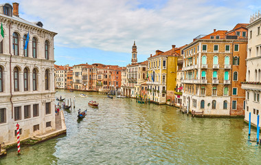 Venetian gondolier punting gondola through canal in Venice, Italy