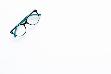 One glasses with transparent lenses on white background top view copy space
