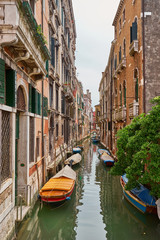 Fototapeta na wymiar Typical small canal in Venice with nice bridges and boats