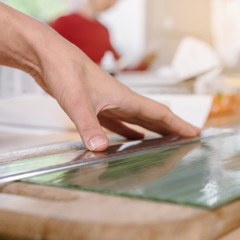 Closeup of artist measuring piece of glass before making mosaic