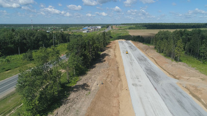Construction of toll roads in rural areas. Aerial view construction of a new highway next to the old highway.