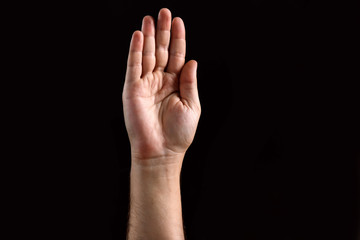 Male palm raised up, isolated on a dark background. Isolate