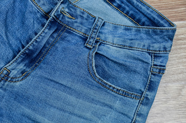 Fototapeta premium jeans on the background, blue jeans lie on a wooden background,