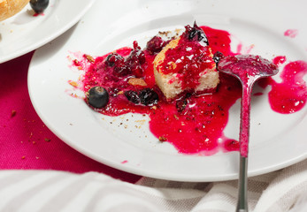 Delicious toasts bread with homemade currant jam on bright crimson tablecloth