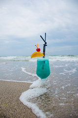 Blue coctail in the glass on the sea background
