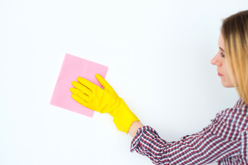 household chores and tidying up. woman cleaning and wiping surface wearing yellow rubber protective glove