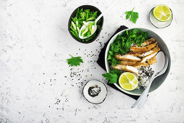 Rice chicken breast bowl with spring green onions and herbs