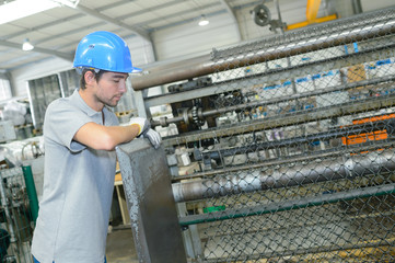 Worker supervising production of fencing wire